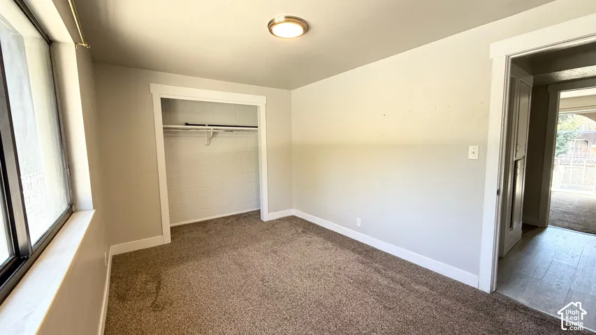 Carpeted interior space with a closet, window, and flush-mount ceiling light