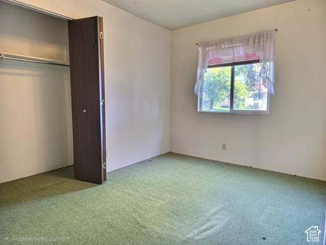 Room featuring carpeting, a built-in closet with a hinged door, and a horizontal sliding window