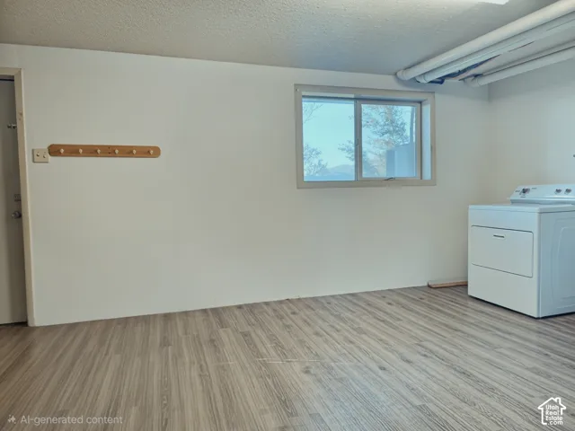 Laundry space featuring wood-finish flooring, white walls, a horizontal sliding window, and a wall-mounted wooden coat rack
