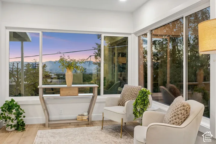Expansive window wall with mountain scenery, recessed lighting, and wood-finish flooring