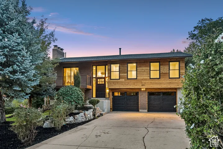 Modern exterior with horizontal wood siding, rick accents, and two-car garage