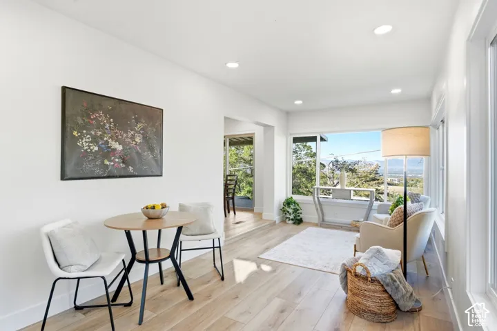 Bright interior with recessed lighting, expansive windows, wood-finish flooring, and white walls