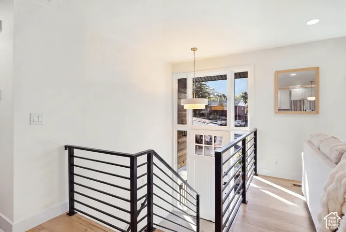 Entry featuring a white paneled door with glass inserts, transom windows, and a hanging pendant light fixture