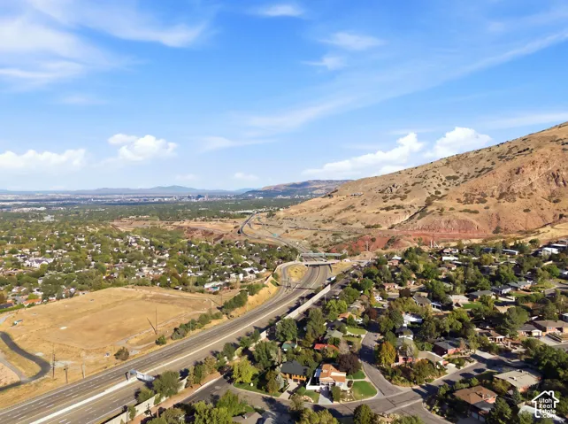 Residential area with established landscaping, highway access, and mountain backdrop