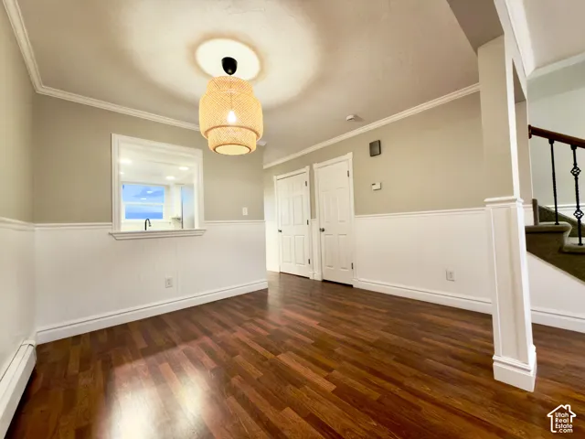 Dining area with laminate flooring, white wainscoting and crown molding