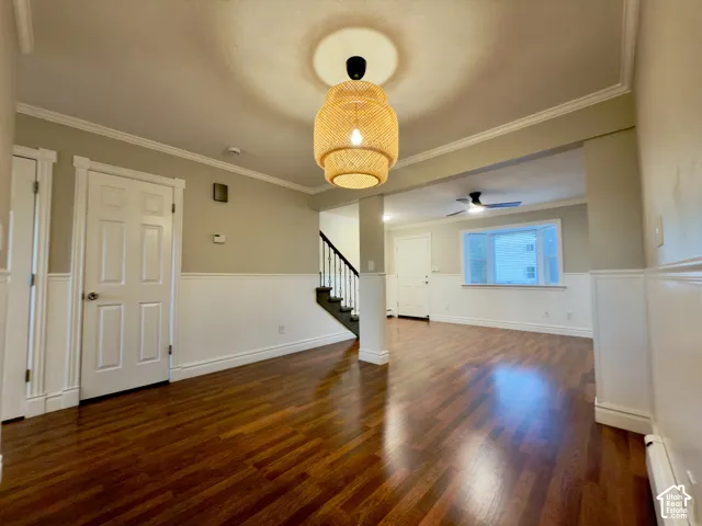 Dining & family rooms with laminate flooring, wainscoting, crown molding, ceiling fan, and bay window