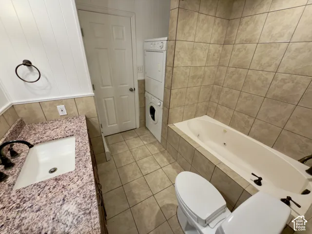 Built-in jetted tub, tile-surround bathtub, vanity with integral sink, granite countertop, tile flooring & laundry room