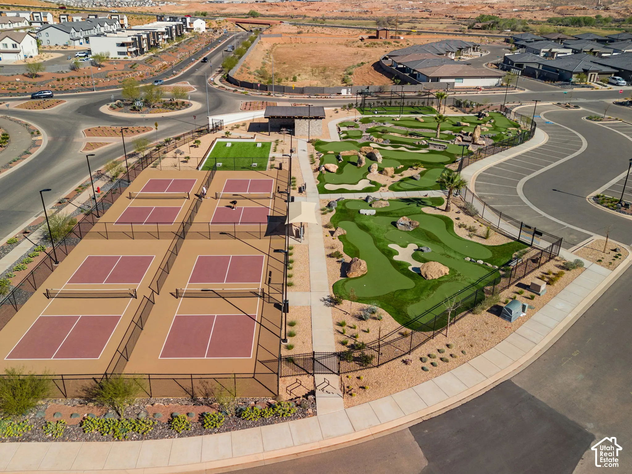 Multiple pickleball courts, expansive mini-golf course, artificial turf activity area, shaded gathering pavilion, and paved walkways