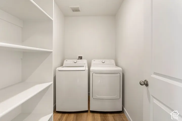 Built-in shelving unit, wood-finish flooring, white walls, and a white door with a round knob
