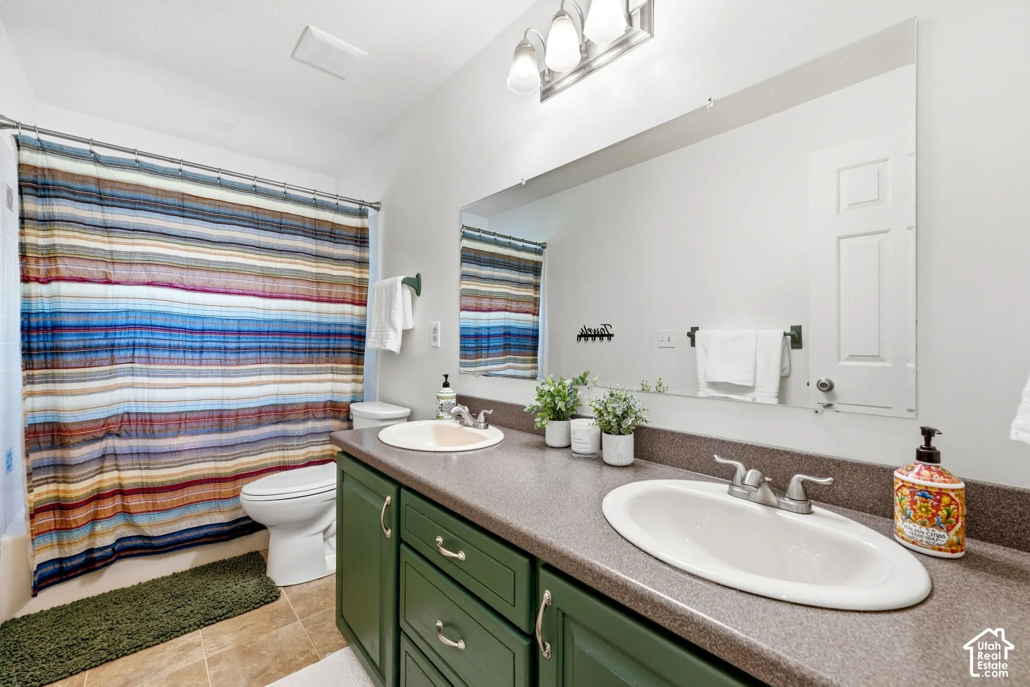 Dual basin vanity with green cabinetry and integrated countertop