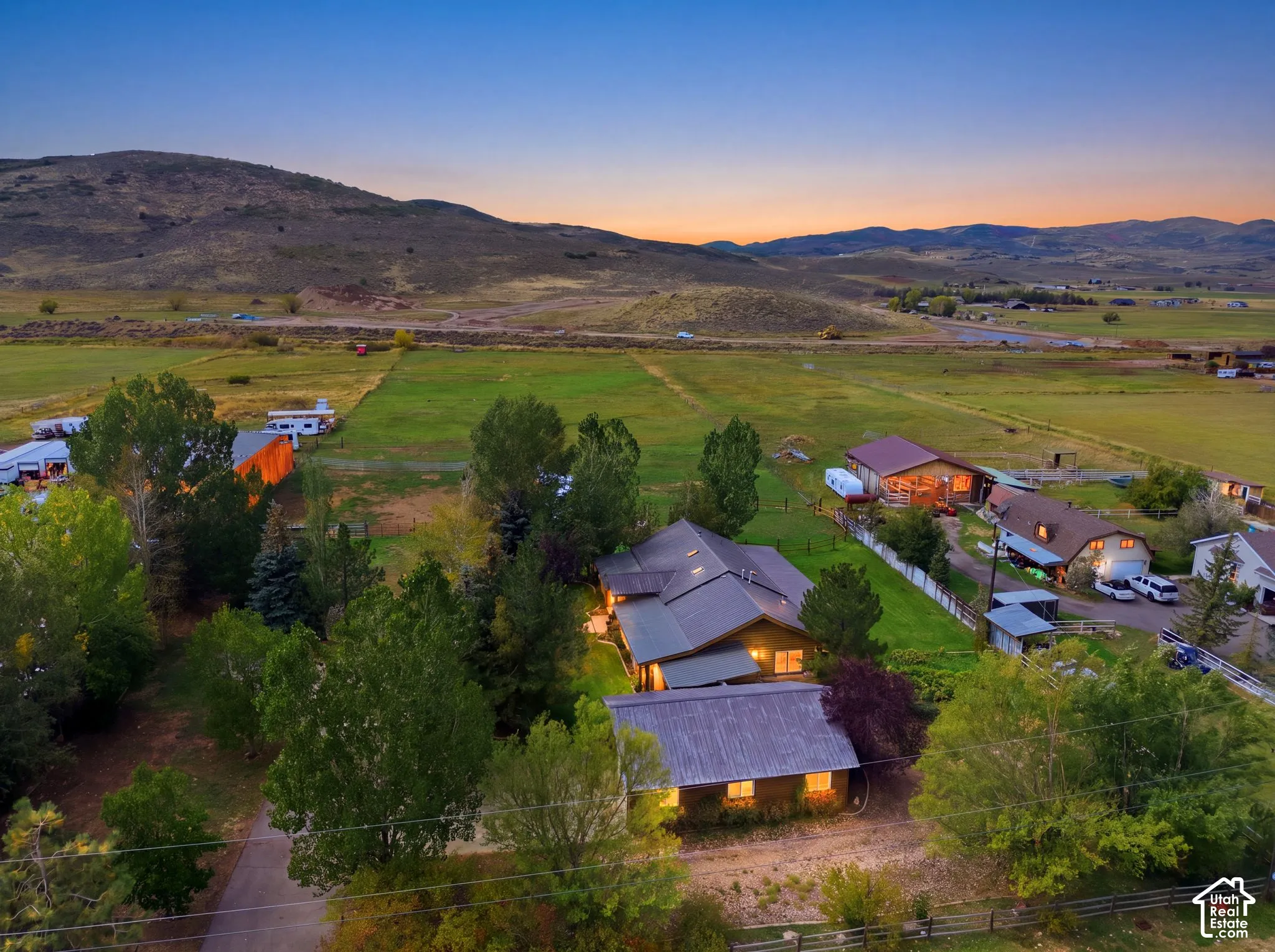 Expansive property featuring multiple structures, mature trees, and agricultural fields