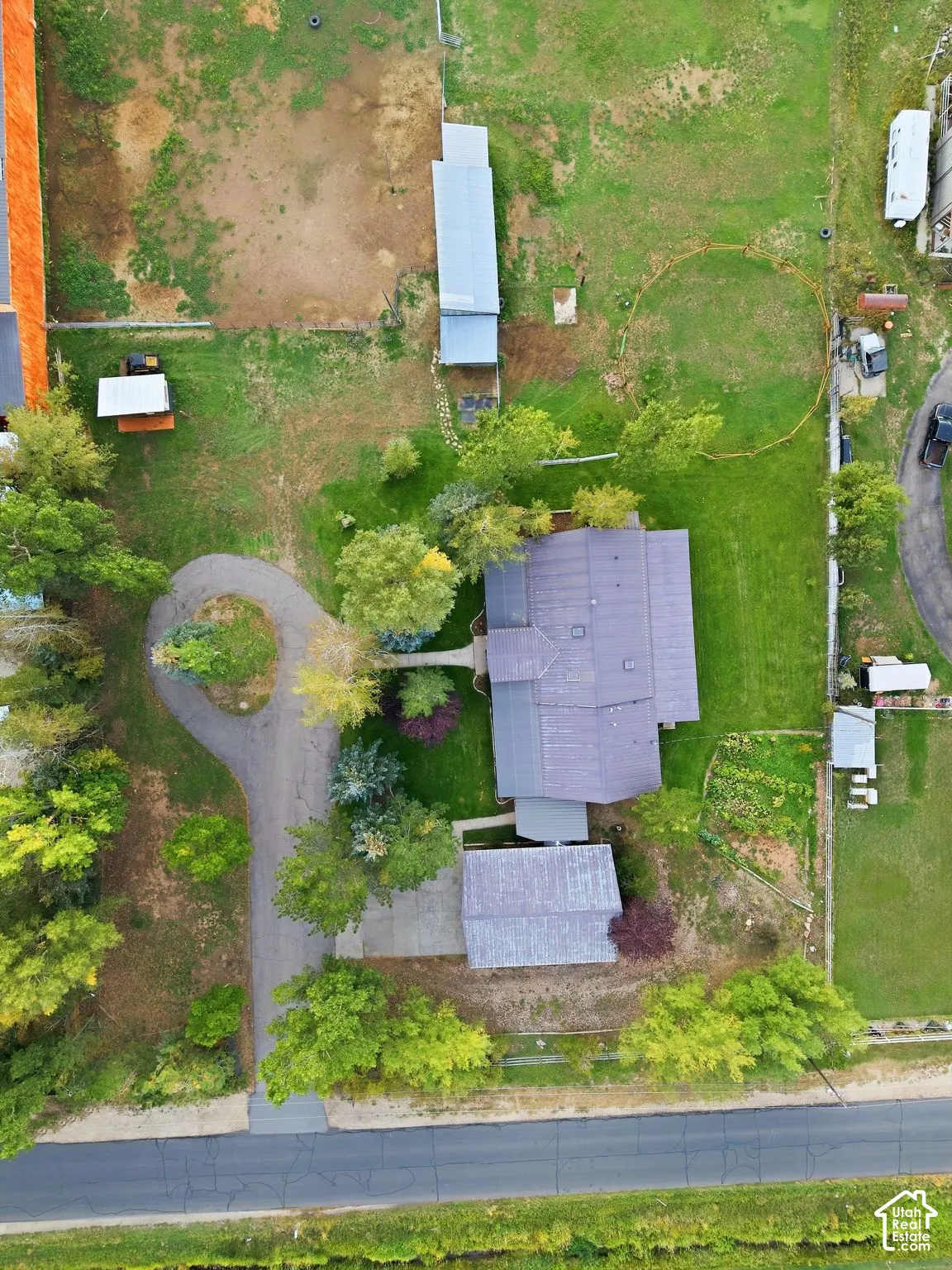 Gravel driveway, circular drive, detached structure, expansive land, and mature trees