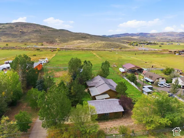 Expansive property featuring multiple structures, mature trees, and vast open fields