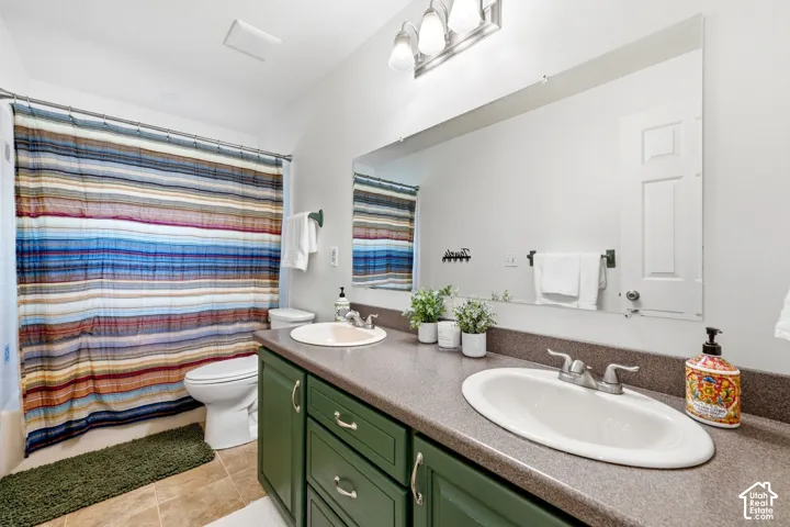 Dual basin vanity with green cabinetry and integrated countertop