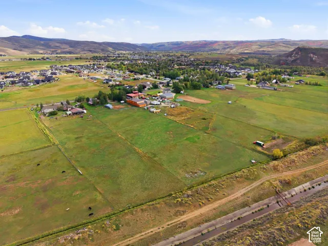 Expansive green fields, distant mountains, and a clear water channel