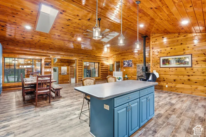 Expansive wood-paneled ceiling, wood-finish flooring, recessed lighting, and a skylight