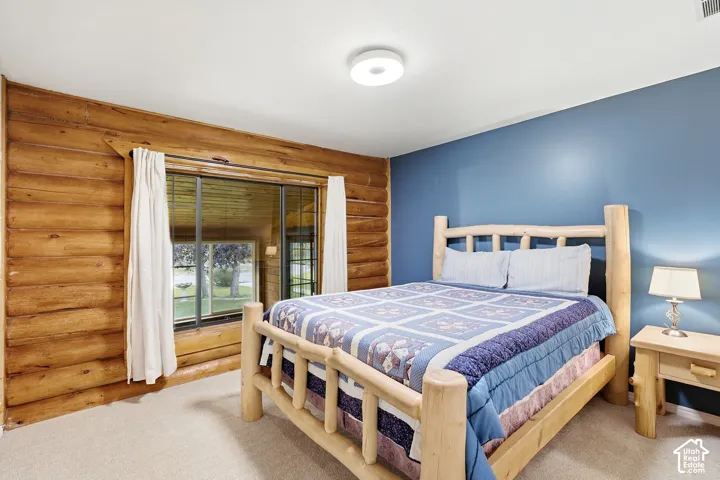 Log wall detailing and a large window with white drapery