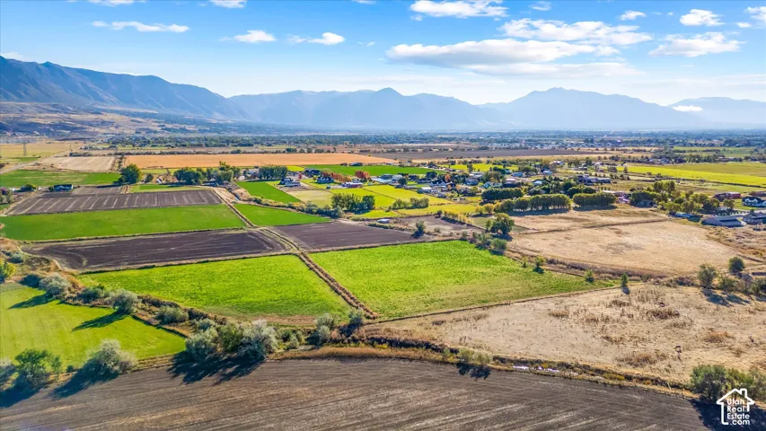 Expansive property featuring varied agricultural fields and distant mountain ranges