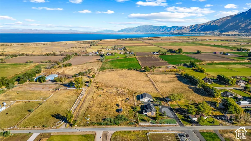Expansive land parcels with diverse terrain, bordered by a large body of water and distant mountains