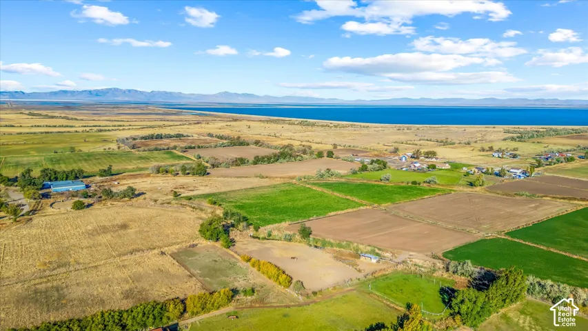 Expansive land parcels featuring cultivated fields, natural terrain, and distant water frontage