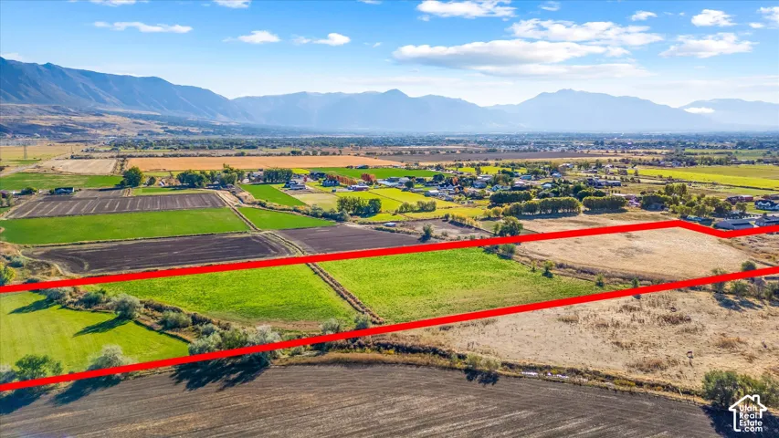 Expansive land parcel featuring open fields and distant mountain ranges