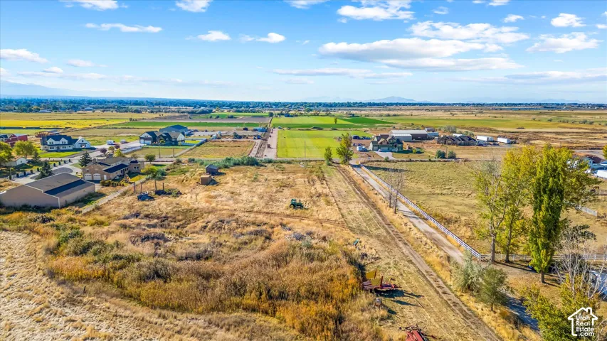 Expansive property featuring a gravel drive, mature trees, and distant mountain backdrops