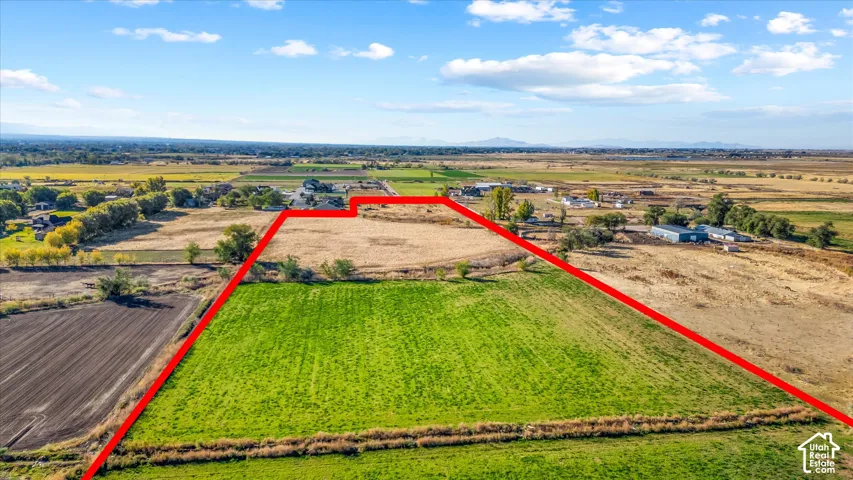 Expansive land parcel featuring open fields and distant mountain scenery