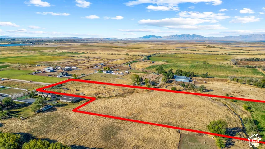 Expansive land parcel featuring open fields, distant mountains, and a clear sky