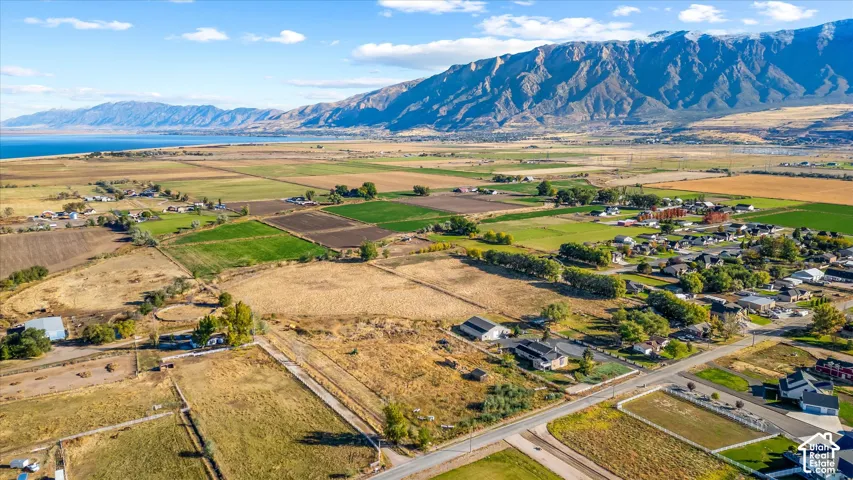 Expansive agricultural land with a prominent mountain backdrop and a distant body of water
