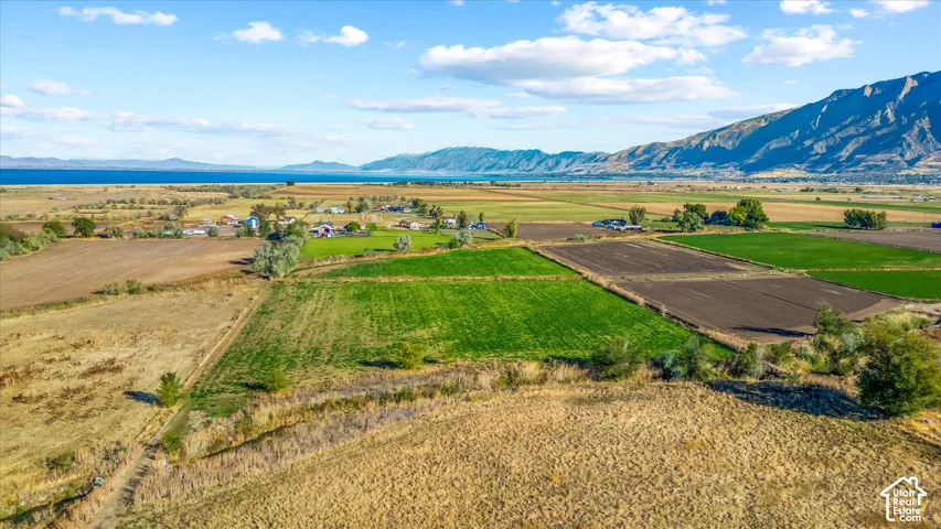 Expansive agricultural landscape featuring cultivated fields and a distant lake