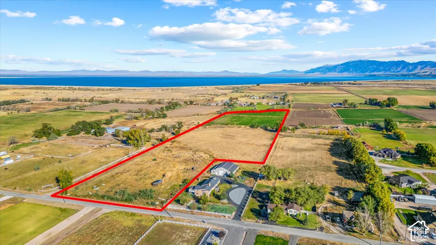 Expansive land parcel featuring open fields and distant water body