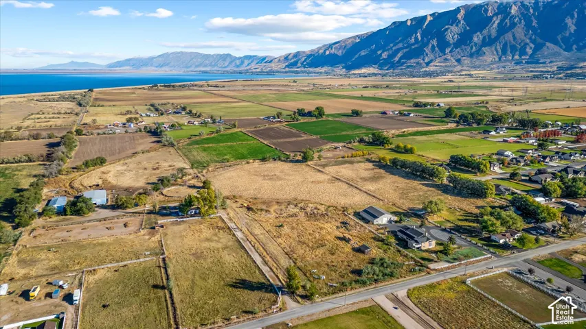 Expansive land parcels with adjacent residential areas, bodies of water, and mountainous terrain