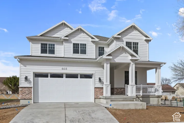 Two-story residence featuring white siding and brick accents