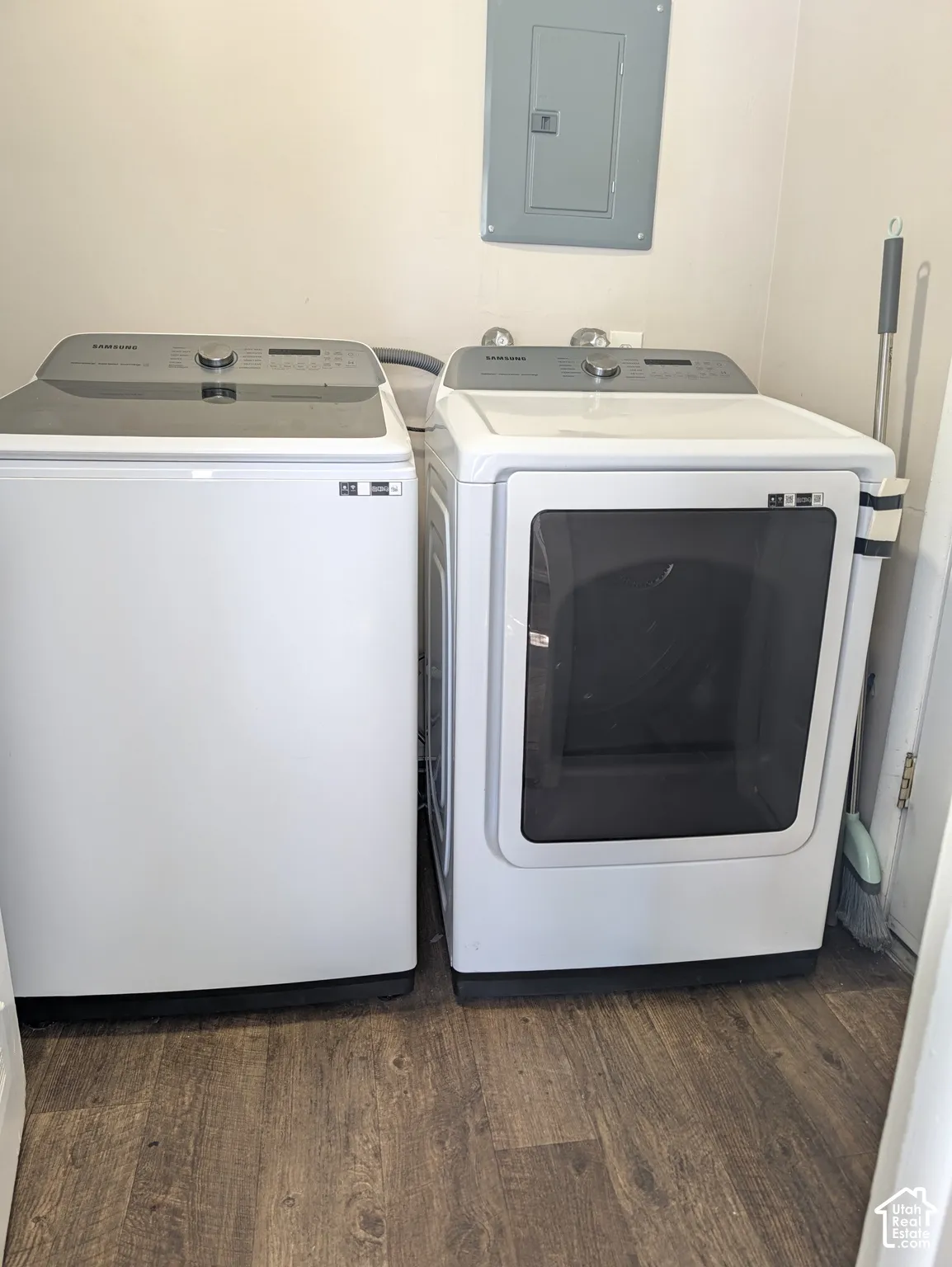 Laundry area featuring wood-finish flooring and a visible electrical panel