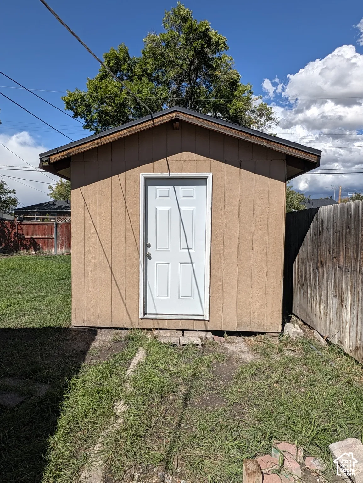 Detached storage shed with a panel door and a sloped roof