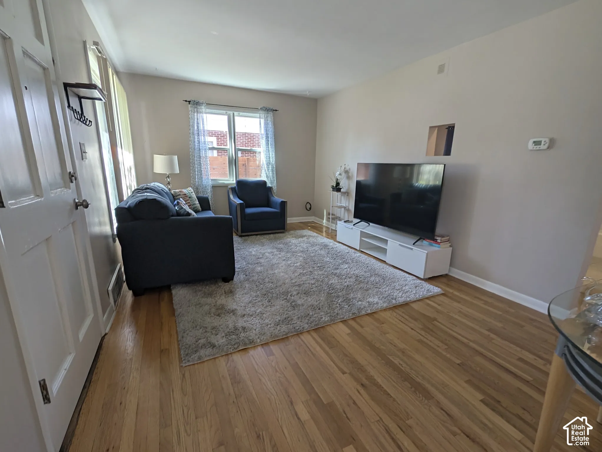 Wood-finish flooring, neutral wall tones, and a window with natural light