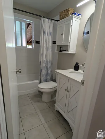 Bathroom featuring a built-in tub with tile surround, white vanity with integrated sink, and wall-mounted storage cabinet