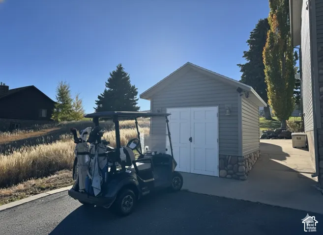 Detached garage structure with horizontal siding and a stone base