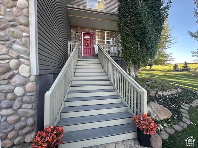 Stone facade accenting composite siding, leading to a covered porch with a vibrant entry door