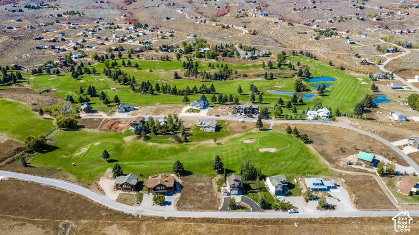 Expansive golf course setting featuring manicured greens, water features, and surrounding properties