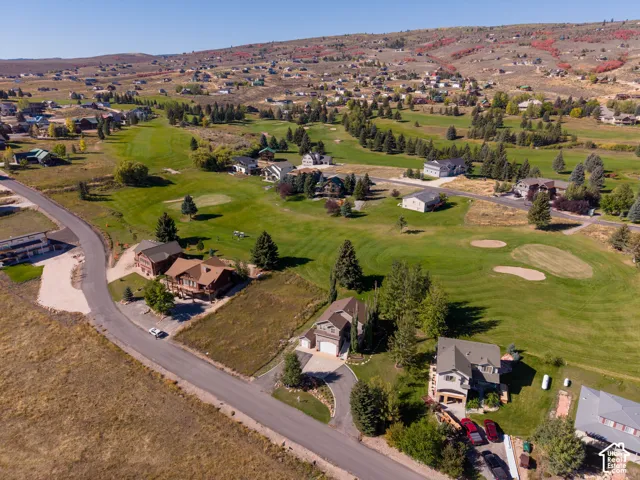 Aerial perspective showcasing a residential area with a golf course backdrop