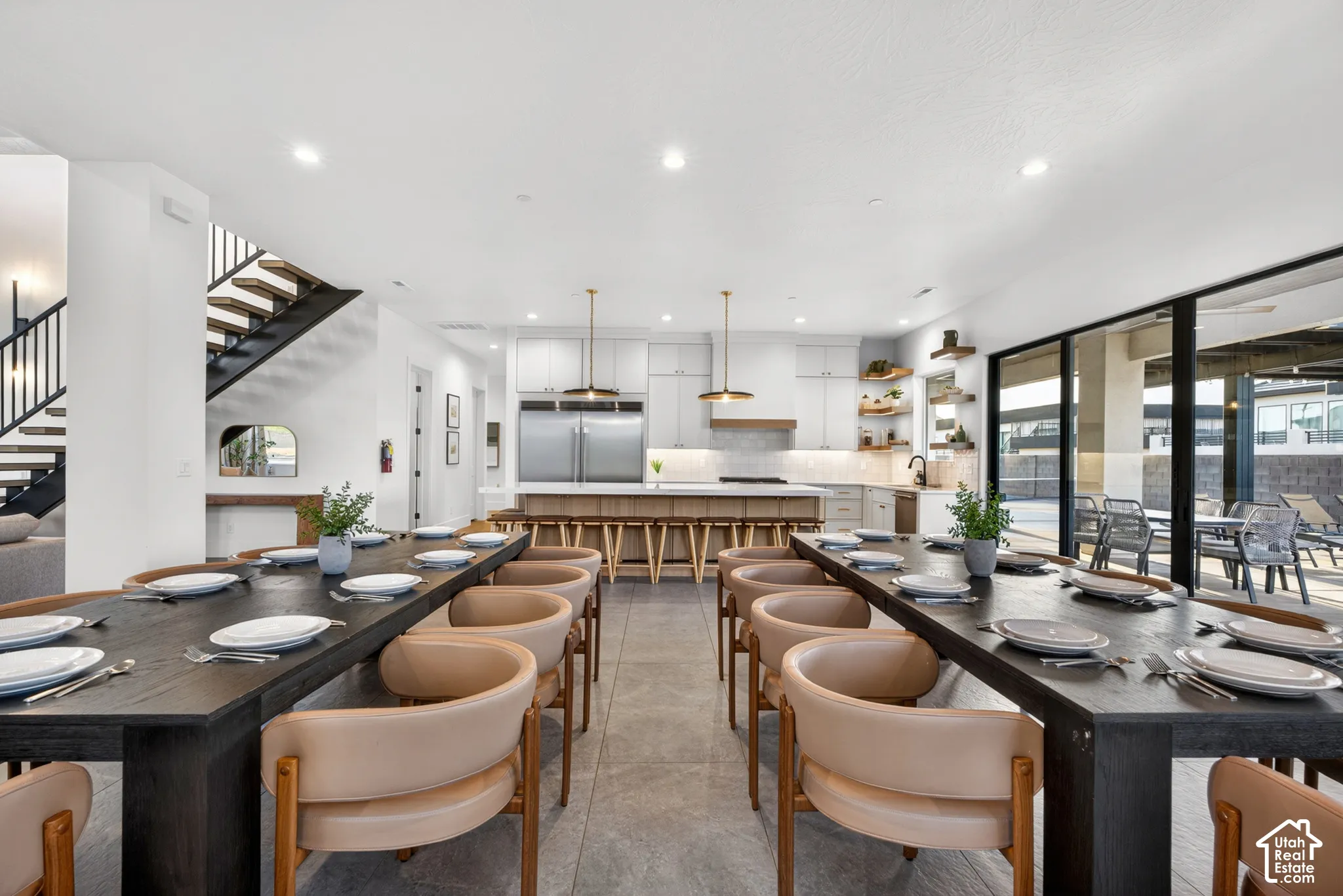 Open-concept living area with a contemporary kitchen, expansive dining space, and large sliding glass doors leading to an outdoor area