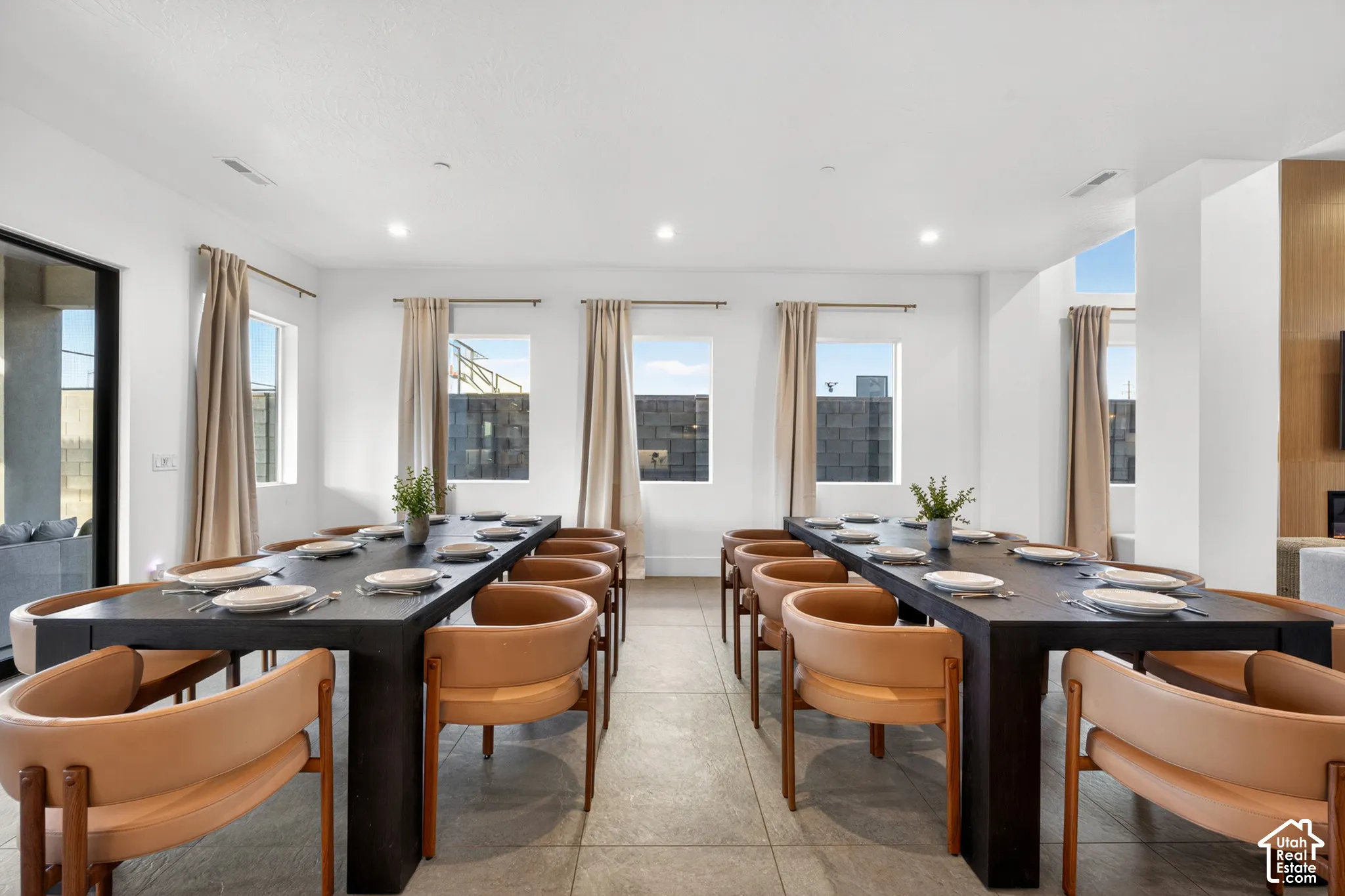 Recessed lighting illuminates the tiled flooring and multiple rectangular windows