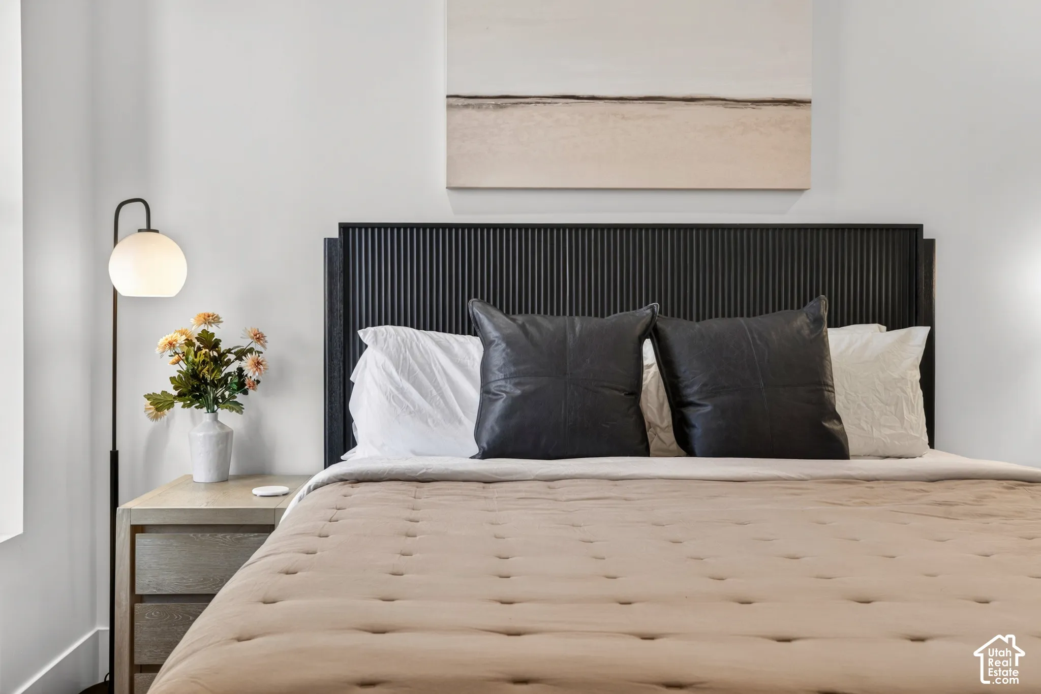 Vertical slat headboard, light wood-finish nightstand, and a contemporary floor lamp