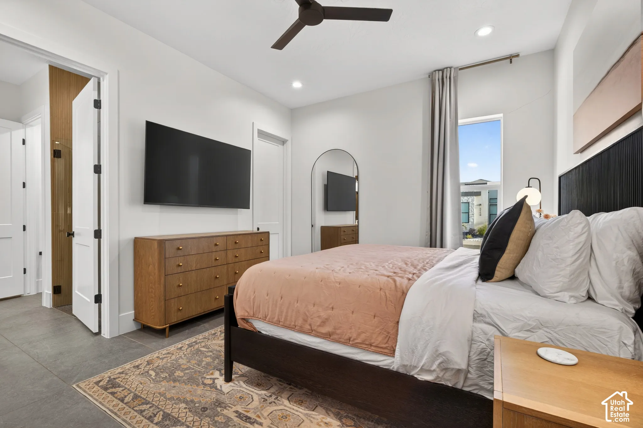 Recessed lighting, ceiling fan, hard surface flooring, wall-mounted television, and a window with curtain rod