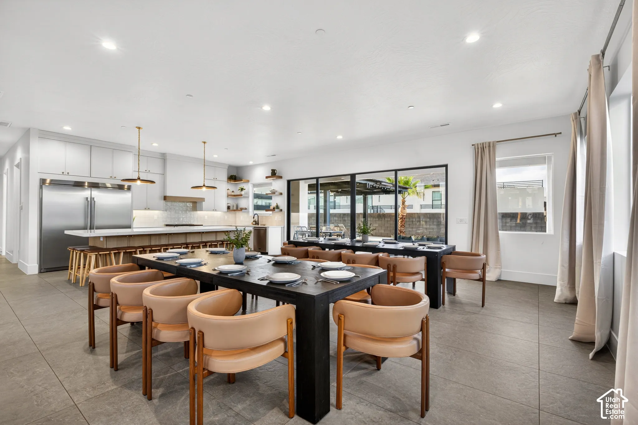 Open-concept living area with a gourmet kitchen, large center island with seating, stainless steel appliances, and expansive sliding glass doors