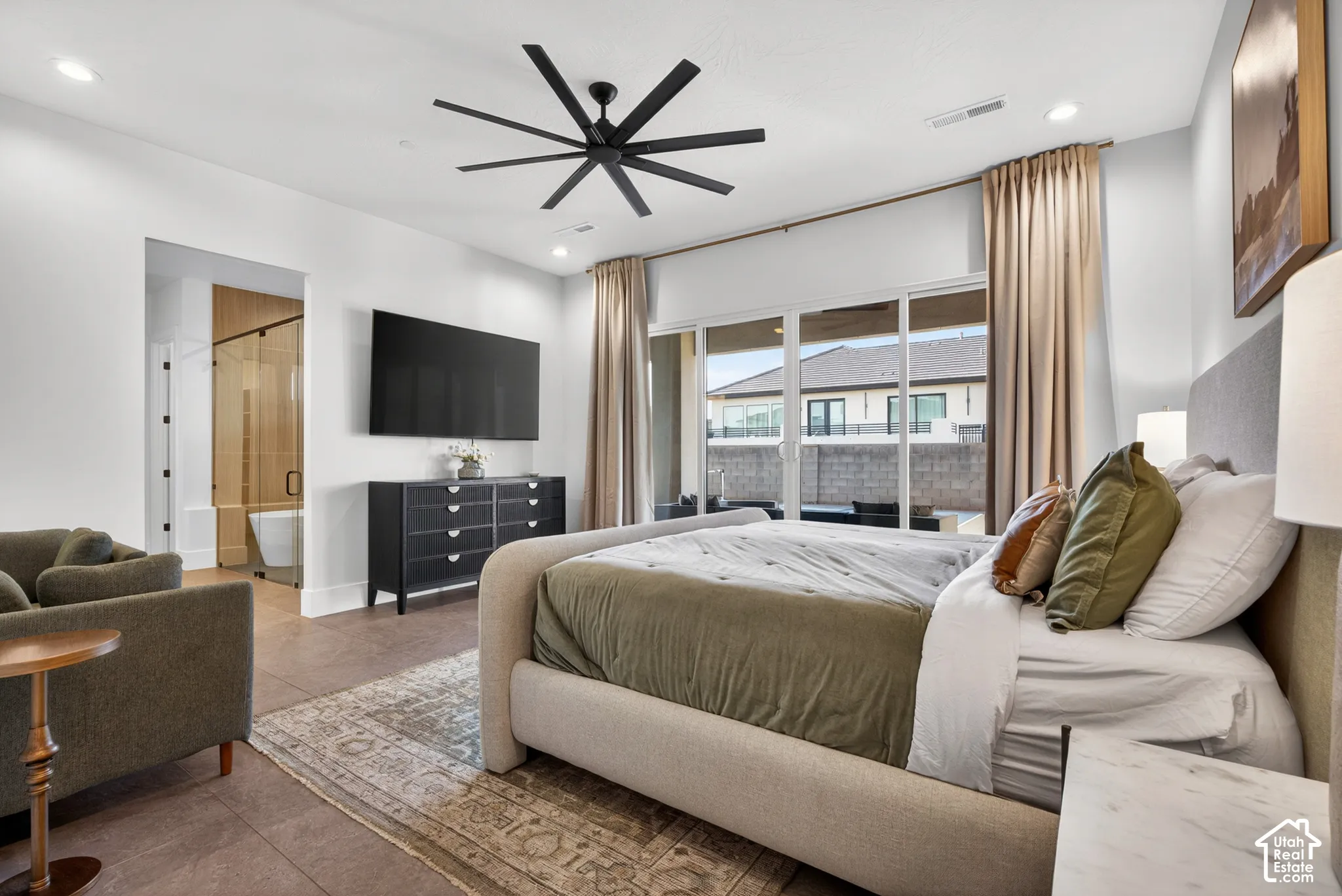 Recessed lighting, ceiling fan, sliding glass door to exterior, and a freestanding soaking tub