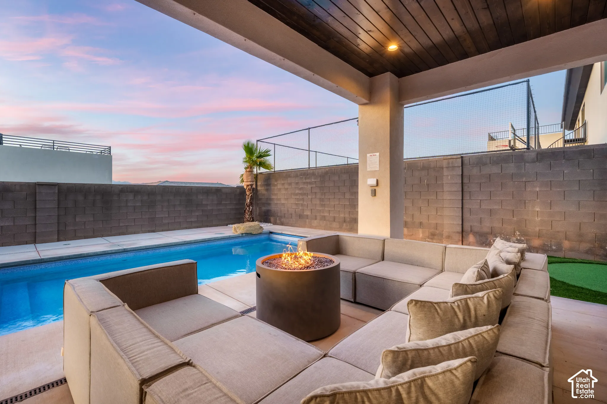 Outdoor pool with integrated fire pit, expansive patio, and wood-finish ceiling