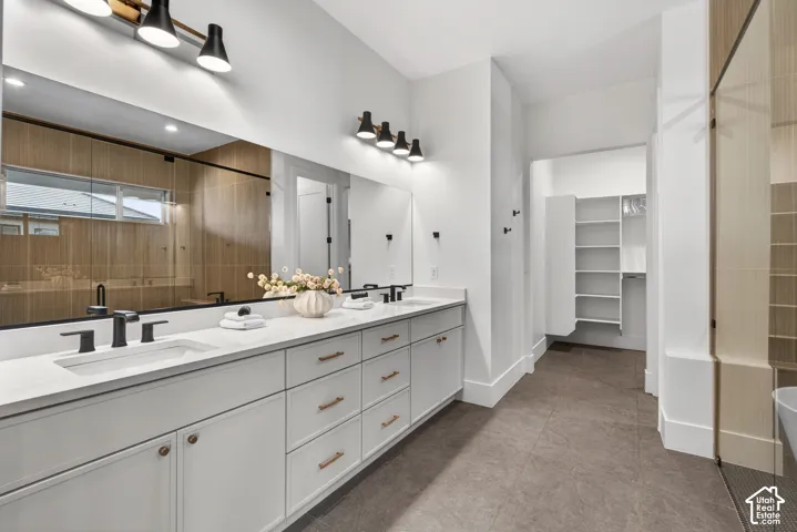 Dual vanity with white cabinetry, matte black fixtures, and a large integrated mirror