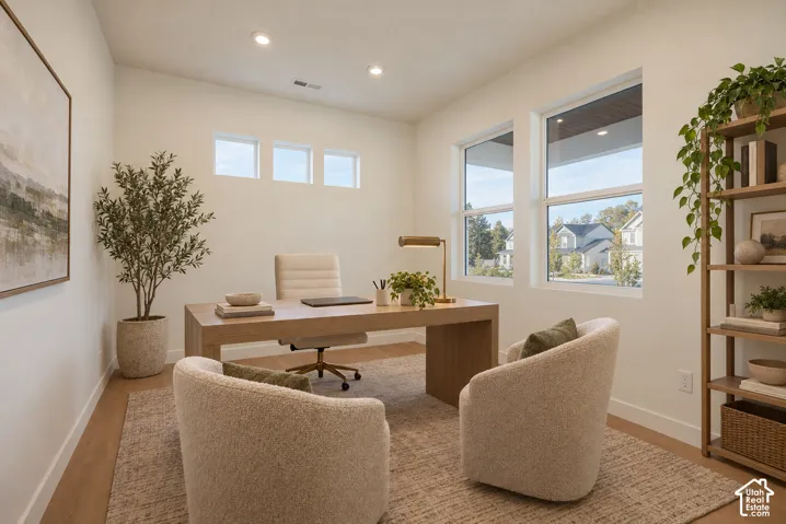 Recessed lighting, wood-finish flooring, multiple windows, and a built-in shelving unit